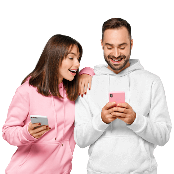 Zwei junge Personen l&auml;cheln und schauen auf Ihr Smartphone.