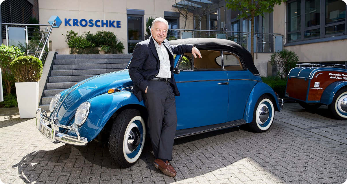 Christoph Kroschke lehnt sich an einen blauen VW K&auml;fer und l&auml;chelt in die Kamera.
